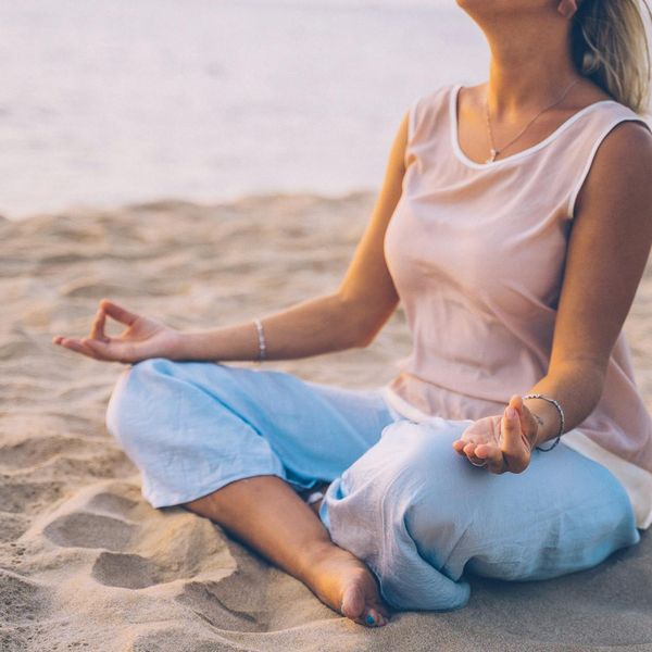Person meditating in a peaceful natural setting, symbolizing balance and energy.